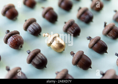 Muster der Eiche Eicheln auf natürlichen, grünen Hintergrund mit einem golden Acorn in der Mitte Stockfoto