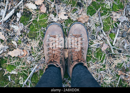 Weibliche Leder vintage Stiefel stehen auf grün Moos Wald Hintergrund Stockfoto
