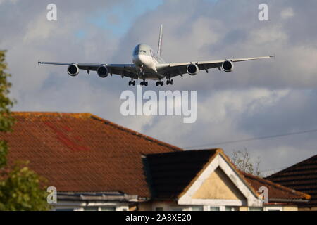 Qatar Airways Airbus A380 A7-APD Tiefflug über die Dächer am Flughafen London Heathrow, Großbritannien Stockfoto