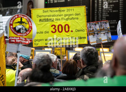 11 November 2019, Hessen, Frankfurt/Main: Demonstranten stehen am 300 Montag Demonstration der Fluglärm Demonstranten im Terminal 1 des Frankfurter Flughafens. Foto: Frank Rumpenhorst/dpa Stockfoto