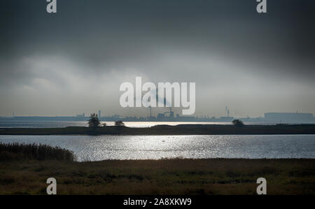 Blick von der Deutschen Insel Poel über die Ostsee an die industrielle Hafen Wismar an einem trostlosen bewölkten Tag, kopieren Raum in den dunklen Himmel Stockfoto