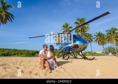 Macao Beach. Dominikanische Republik Oktober 7, 2015. Paar ruht auf dem Strand im Hintergrund mit einem Hubschrauber. Sightseeing Hubschrauber Stockfoto
