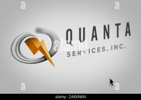 Logo der öffentlichen Unternehmen Quanta Services Inc. auf einem Bildschirm in der Nähe angezeigt. Credit: PIXDUCE Stockfoto