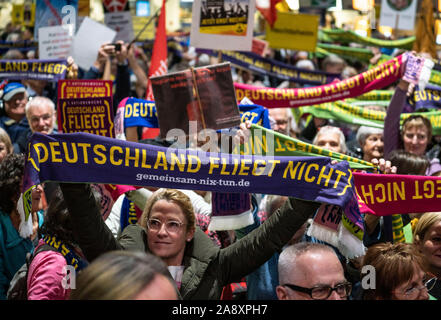 11 November 2019, Hessen, Frankfurt/Main: Demonstranten stehen am 300 Montag Demonstration der Fluglärm Demonstranten im Terminal 1 des Frankfurter Flughafens. Zu Beginn des 'Deutschland fliegt nicht'-Kampagne, Teilnehmer halten Schals. Foto: Frank Rumpenhorst/dpa Stockfoto