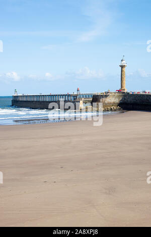 Am wunderschönen Sandstrand in Whitby zusammen mit Sea Wall und Eintritt in den Fluss Esk Mündung und Leuchtturm North Yorkshire England Großbritannien Stockfoto