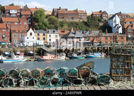 Kleine Boote für die Küstenfischerei und ein altes Rettungsboot, das am Fluss Esk festgemacht ist, sowie Hummer- und Krabbentöpfe am Kai in Whitby North Yorkshire UK Stockfoto