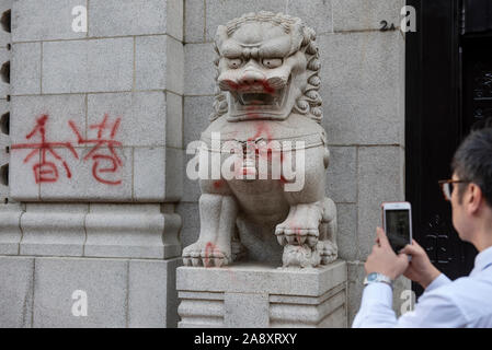 Hongkong, China. 11 Nov, 2019. Ein pendler nimmt ein Foto eines vandalized Bank von China-Niederlassung Gebäude während der Demonstration. regierungsfeindlichen Demonstranten ein Generalstreik organisiert, Einrichtung Straße Barrikaden und vandalize Hong Kongs MTR U-Bahn Stationen als Demonstrationen in seinen fünf Monate fortgesetzt. Credit: SOPA Images Limited/Alamy leben Nachrichten Stockfoto