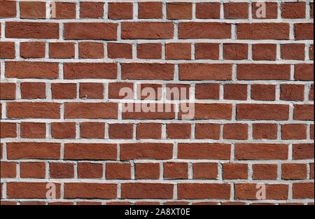 Bräunlich Red brick wall. Oberfläche einer Außenwand eines Gebäudes. Schön sauber, symmetrischen architektonische Details eines Gebäudes. Farbe Bild. Stockfoto