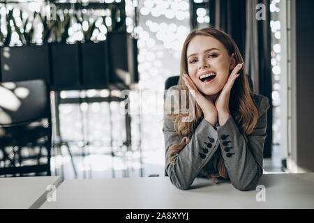 Ein lächelndes Office Girl posiert am Schreibtisch Stockfoto