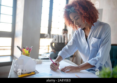 Curly vielversprechende Interior Designer arbeiten an neuen Projekt Stockfoto