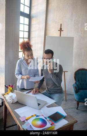 Innenarchitekt am Telefon sprechen und zuhören Sekretär Stockfoto