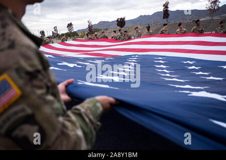 El Paso, Texas, USA. 11 Nov, 2019. Soldaten des 1.Bataillon, 77. Armor Regiment, 3. gepanzerte Brigade Combat Team 'Bulldogge'', 1st Armored Division, eine amerikanische Flagge während der Feier ist ein Veteran in El Paso, Texas. Quelle: Joel Engel Juarez/ZUMA Draht/Alamy leben Nachrichten Stockfoto