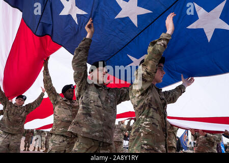 El Paso, Texas, USA. 11 Nov, 2019. Soldaten des 1.Bataillon, 77. Armor Regiment, 3. gepanzerte Brigade Combat Team 'Bulldogge'', 1st Armored Division, eine amerikanische Flagge während der Feier ist ein Veteran in El Paso, Texas. Quelle: Joel Engel Juarez/ZUMA Draht/Alamy leben Nachrichten Stockfoto