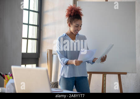 Designer in der Nähe von Zeichnung Staffelei und Skizzen Stockfoto