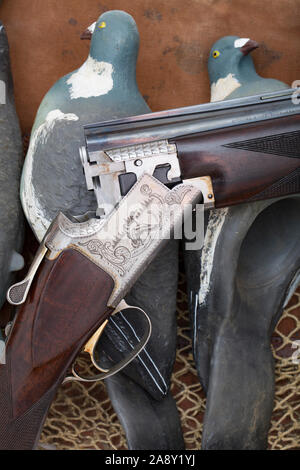 Ein studio Foto einer Browning B125 12-Bohrung über und - unter Schrotflinte ruht auf einem alten gamebag und künstliche Ringeltaube Lockvögel. In Großbritannien ist die woodp Stockfoto