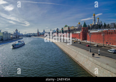 Kreml, Moskau, Russland, 25. März 2018: Moscova Fluss mit touristischen Boot und Kreml Stadtbild mit blauem Himmel Stockfoto