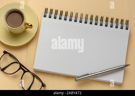 Leere Spirale Art Skizzenbuch mit einer Tasse Kaffee gegen strukturierte Krepppapier Stockfoto