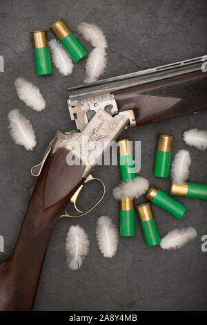 Ein studio Foto einer Browning B125 12-Bohrung über und - unter Schrotflinte mit Holz pigeon Feathers und 12-Bohrung Munition um ihn herum. Ringeltaube kann caus Stockfoto