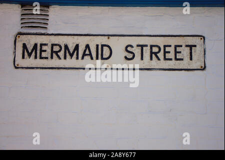 Straßenschild auf der weißen Wand, Mermaid Street in Rye, East Sussex, UK. Stockfoto