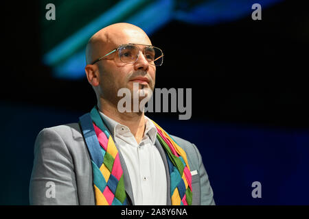 Konstanz, Deutschland. 04 Nov, 2019. Mohamed El Bachiri steht auf der Bühne im Konzil Gebäude nach der Vergabe des Konstanzer Konzilspreis. Um den Hals trägt er den Flügel als ein Zeichen für die Vergabe des Preises. Credit: Felix Kästle/dpa/Alamy leben Nachrichten Stockfoto