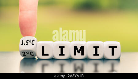 Symbol für eine Begrenzung der globalen Erwärmung. Hand einen Würfel und Änderungen der Ausdruck "2°C-Grenze' zu '1,5 °C limit', oder umgekehrt. Stockfoto