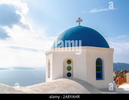 Eine orthodoxe Kirche mit der blauen Kuppel und weiß getünchten Wänden im Dorf Oya in Santorini, Griechenland. Stockfoto