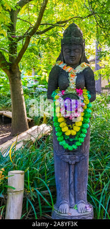 Stein spirituelle Hindu Statue mit bunten Blumen geschmückt, religiösen Hintergrund Stockfoto