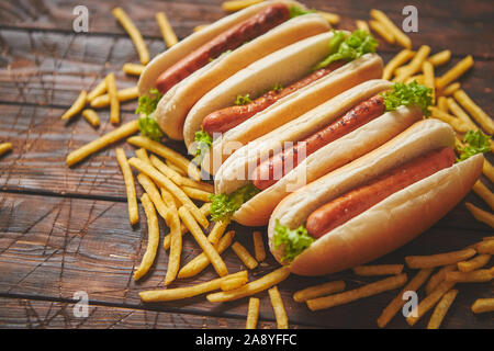 American Hot Dogs sortiert in Reihe. Mit Pommes frites serviert. Stockfoto