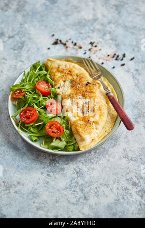 Klassische ei Omelette mit Cherry Tomaten und Rucola Salat auf Seite Stockfoto