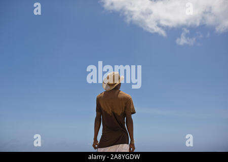 Junger Mann mit einem Stroh Sonnenhut gegen einen blauen Himmel. Stockfoto
