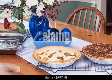 Sortiment von holiday Pies und eine Pfanne mit Brownies. Cherry Pie, Apfelkuchen, Nussbaum Pumpkin Pie, und Deep Chocolate brownies serviert auf einem Pinienwald Ess Stockfoto