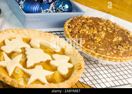 Hausgemachten Apfelkuchen mit weihnachtlichen Gebäck Ausschnitte auf der crusty Top und einem Pumpkin Pie mit einer Walnuss und Zimt Richtfest für eine Kruste. Stockfoto