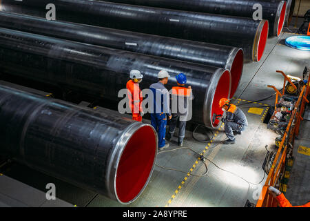 Ingenieure untersuchen neue beschichtete Rohre im Werk. Stockfoto