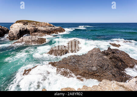 Meer Wellen Felsen über der Küste mit weißen Schaum zu brechen. Stockfoto