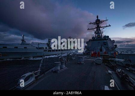 191105-N-UB 406-0092 Norwegische See (Nov. 5, 2019) Die US-Marine geführte Anti-raketen-Zerstörer USS Gridley (DDG101), rechts, Transite neben der Royal Fleet Auxiliary Tide-Klasse Auffüllung tanker Tidesurge (A 138), Links, während eines laufenden Nachschub. Gridley ist unterwegs auf einem geplanten Einsatz als Flaggschiff der Standing NATO Maritime Group eine maritime Operationen durchzuführen und einen kontinuierlichen maritime Fähigkeit zur NATO im nördlichen Atlantik. (U.S. Marine Foto von Mass Communication Specialist 2. Klasse Cameron Stoner) Stockfoto