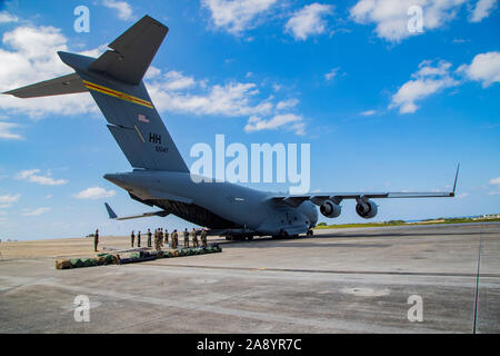 Us-Mitglieder mit Marine Light Attack Helicopter Squadron 169, 3 Marine Flugzeugflügel (MAW) laden ein US Marine Corps AH-1Z Cobra von der US Air Force C-17 Globemaster III Marine Corps Air Station Futenma in Okinawa, Japan, November 11, 2019. Die C-17 ausgeliefert, die cobra als Teil eines MAW halbjährliche Flugzeuge swap innerhalb der Einheit Deployment Program. (U.S. Marine Corps Foto von Lance Cpl. Karis Mattingly) Stockfoto