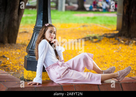 Schöne junge Mädchen an der Paseo Bolivar Square im Stadtzentrum von Cali in Kolumbien sitzen Stockfoto