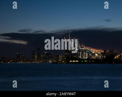 Sonnenuntergang Panorama der Hafen von Miami, Fisher Island und Downtown, bunte Stadt Licht und Biscayne Bay Wasser Stockfoto