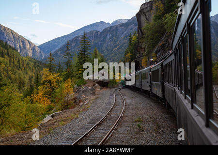 Skagway, Alaska, Vereinigte Staaten - 24 September 2019: Alte historische Eisenbahn Zug wird White Pass mit Touristen während einem bewölkten Sommermorgen. Stockfoto