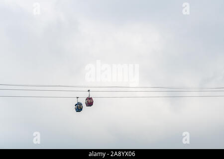 Nha Trang, Vietnam - 11. März 2019: Abend, zwei Antennenkabel Kabinen gegen silve Sky Pass über Port vom Festland zu den touristischen Insel. Stockfoto