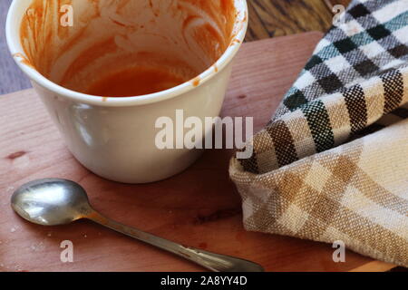 Leere Schüssel mit den Überresten von tomatensuppe, einen Löffel und eine Serviette Stockfoto