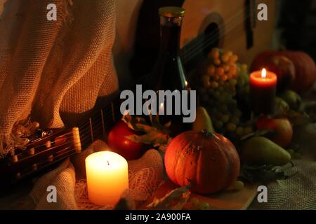 Noch leben die Ernte von kürbis, birnen, äpfel, Trauben und Kerzen, weiches Licht mit einer Flasche Wein und Gitarre auf Sack Stockfoto