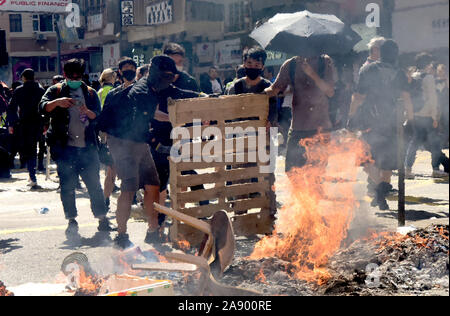 Hong Kong. 11 Nov, 2019. Randalierer setzten Feuer Verkehr in Sai Wan Ho, South China Hong Kong, November 11, 2019 zu lähmen. Nach der lähmenden Traffic über Hongkong während des morgendlichen Berufsverkehrs Randalierer gehalten eskalierende Gewalt an verschiedenen Standorten am Montag von hurling Benzinbomben an Universitäten und in U-Bahnhöfen und Angreifen der Bewohner, die nicht mit Ihnen einverstanden, auch ein Passant in Flammen. Quelle: Xinhua/Alamy leben Nachrichten Stockfoto