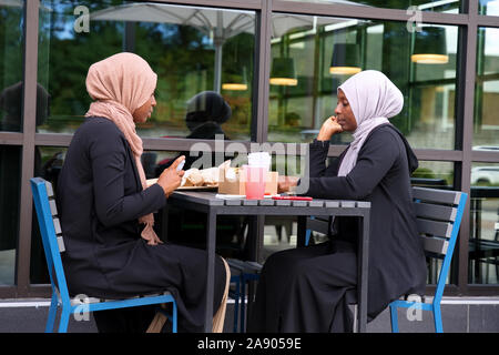 Farmington, CT USA. Sep 2019. Frauen afrikanischer Herkunft in traditionellen kulturellen tragen Essen im Freien an einem New England Restaurant. Stockfoto