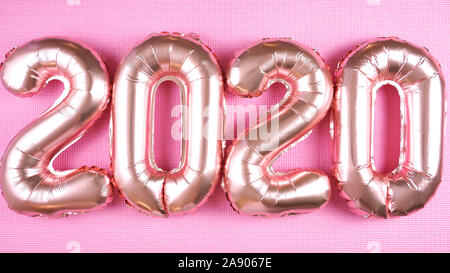Happy New Year's Eve Rose Gold Folie 2020 metallic Ballons auf moderne rosa Hintergrund. Stockfoto