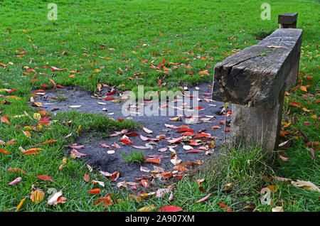 Alte Holzbank in einer Bristol Park, mit Blätter im Herbst um Stockfoto
