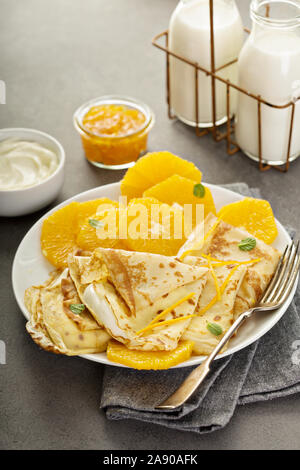 Dünne Crepes Suzette mit Orangenscheiben und Marmelade zum Frühstück Stockfoto