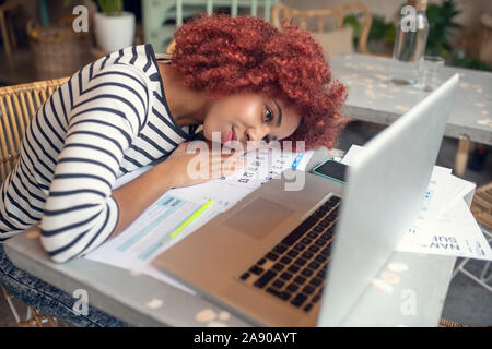 Junge Geschäftsfrau das Gefühl erschöpft nach dem Ausfüllen der Steuererklärung Stockfoto