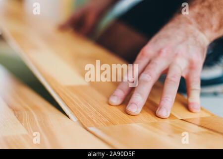 Der master installiert gekonnt Parkett- fußboden-Arbeit während der Schlichten Stockfoto