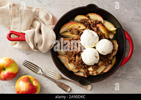 Apple mit Pekannüssen in einer gusseisernen Pfanne bröckeln gekrönt mit Eis Stockfoto